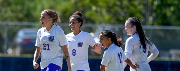 Knights women's soccer players celebrating during a game.